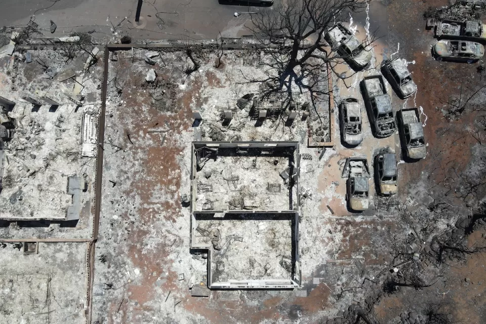 Aerial view of destroyed home and cars after Lahaina, Hawaii wildfires.